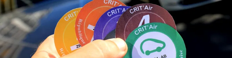 différentes vignettes Crit'Air entre les mains