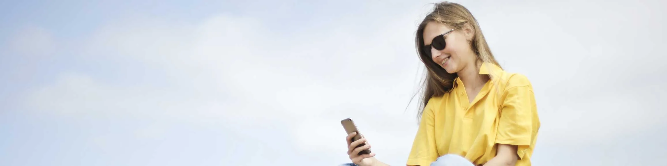 jeune femme souriante avec téléphone en main