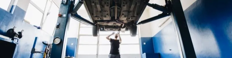 Image d'une voiture dans un garage en train d'être inspectée