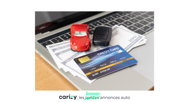 petites voitures, carte bancaire et billets de banque sur un ordinateur portable