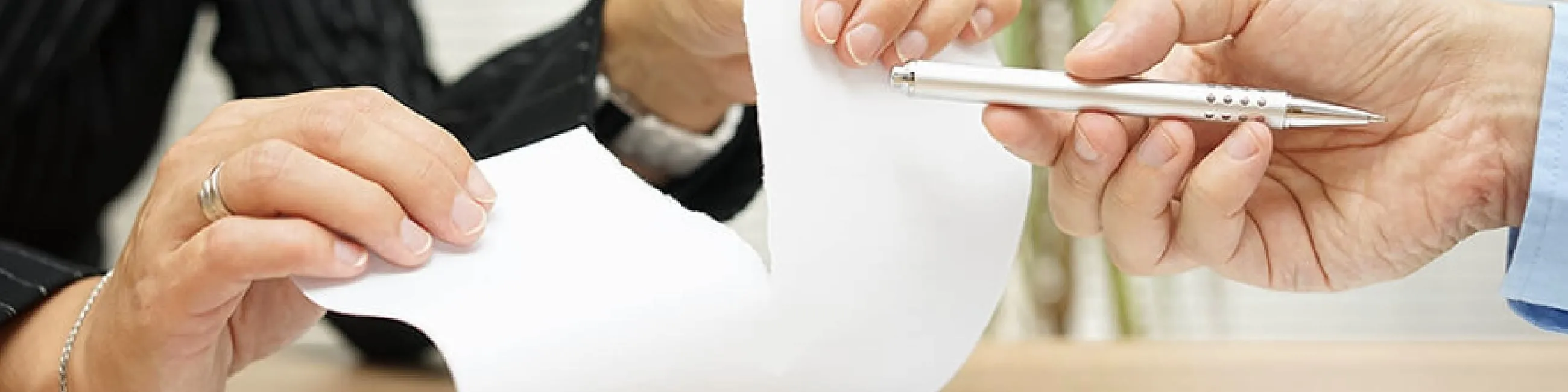 deux personnes avec des papiers et un stylo dans les mains