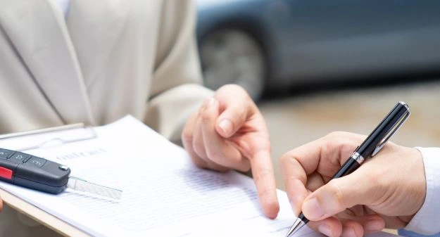 personnes qui signent un contrat avec clé de voiture