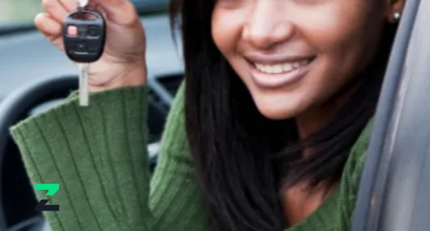 jeune femme souriante qui montre sa clé de voiture